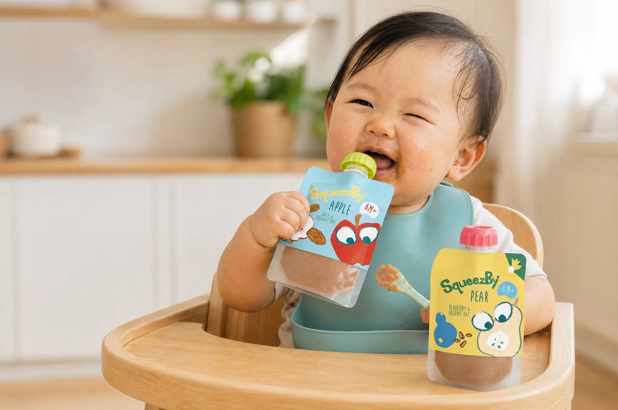 A baby in a high chair enjoying Squeezby apple and pear pouches