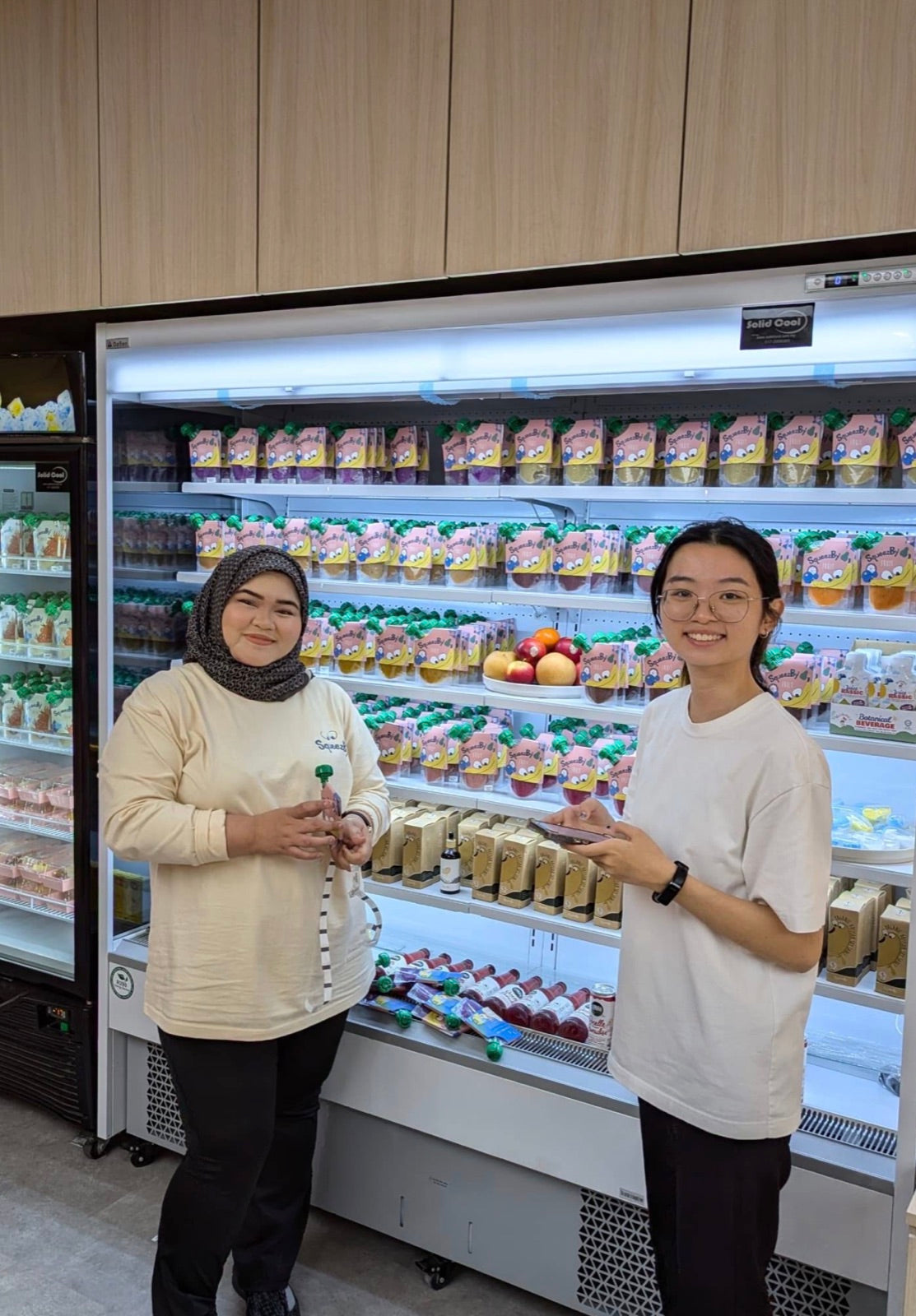 Squeezby staff beside the chilled pouch display